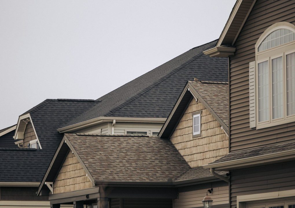 a row of houses with brown shingles and white windows